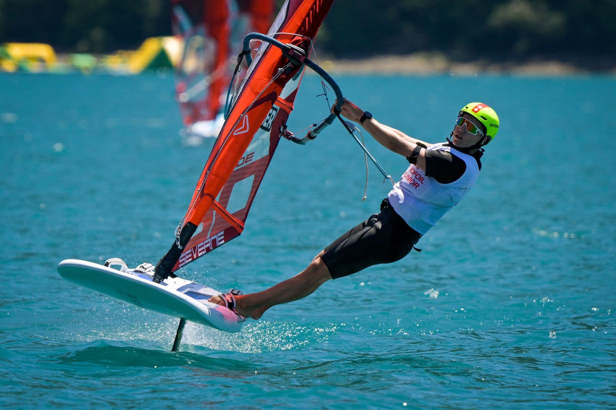 Devin Hauser mit gestrecktem Körper am Trapez, Foil frei über dem Wasser