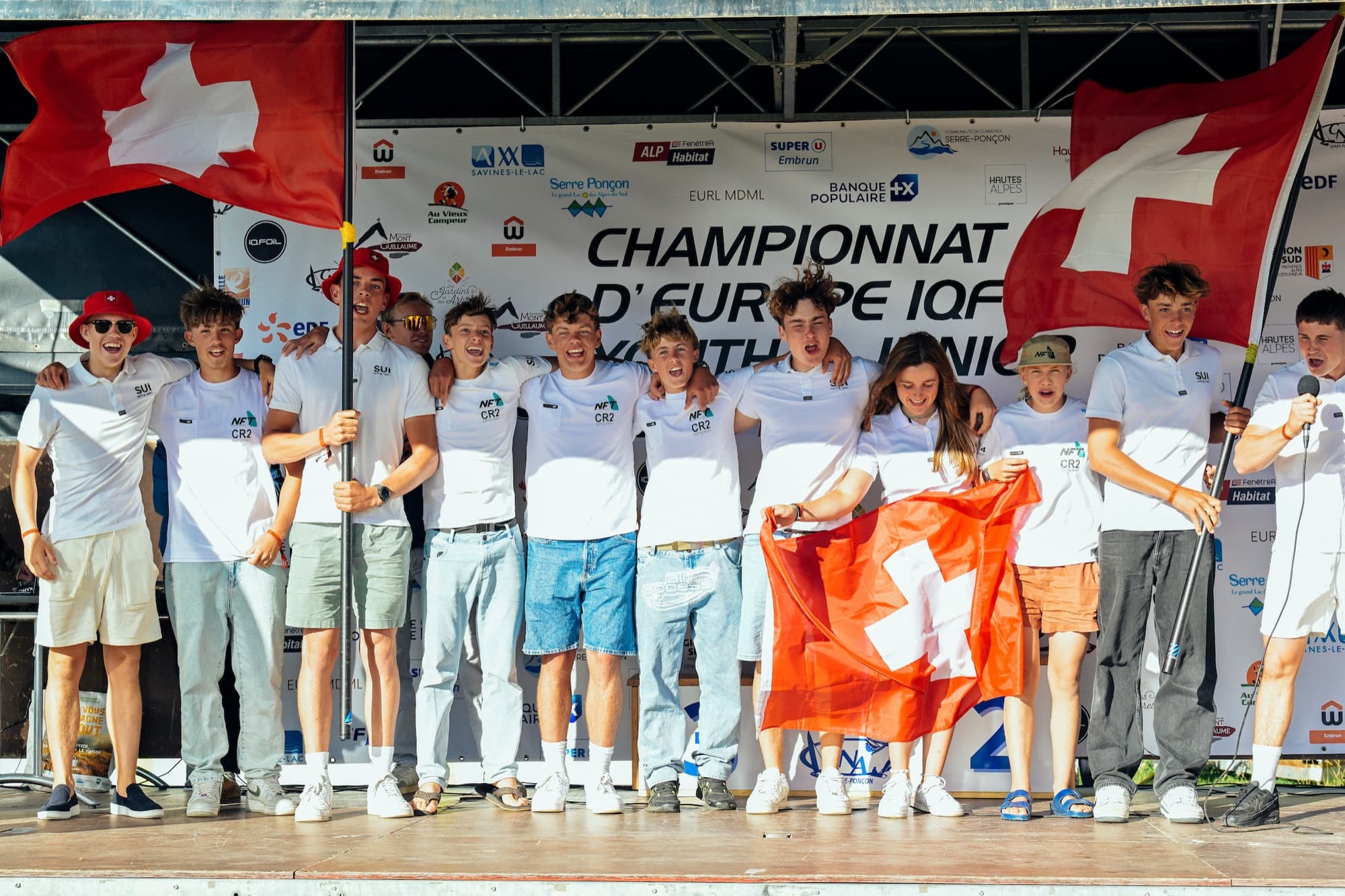 Das Schweizer Team auf der Bühne der Eröffnungsfeier, zwei Schweizer Fahnen über der Gruppe