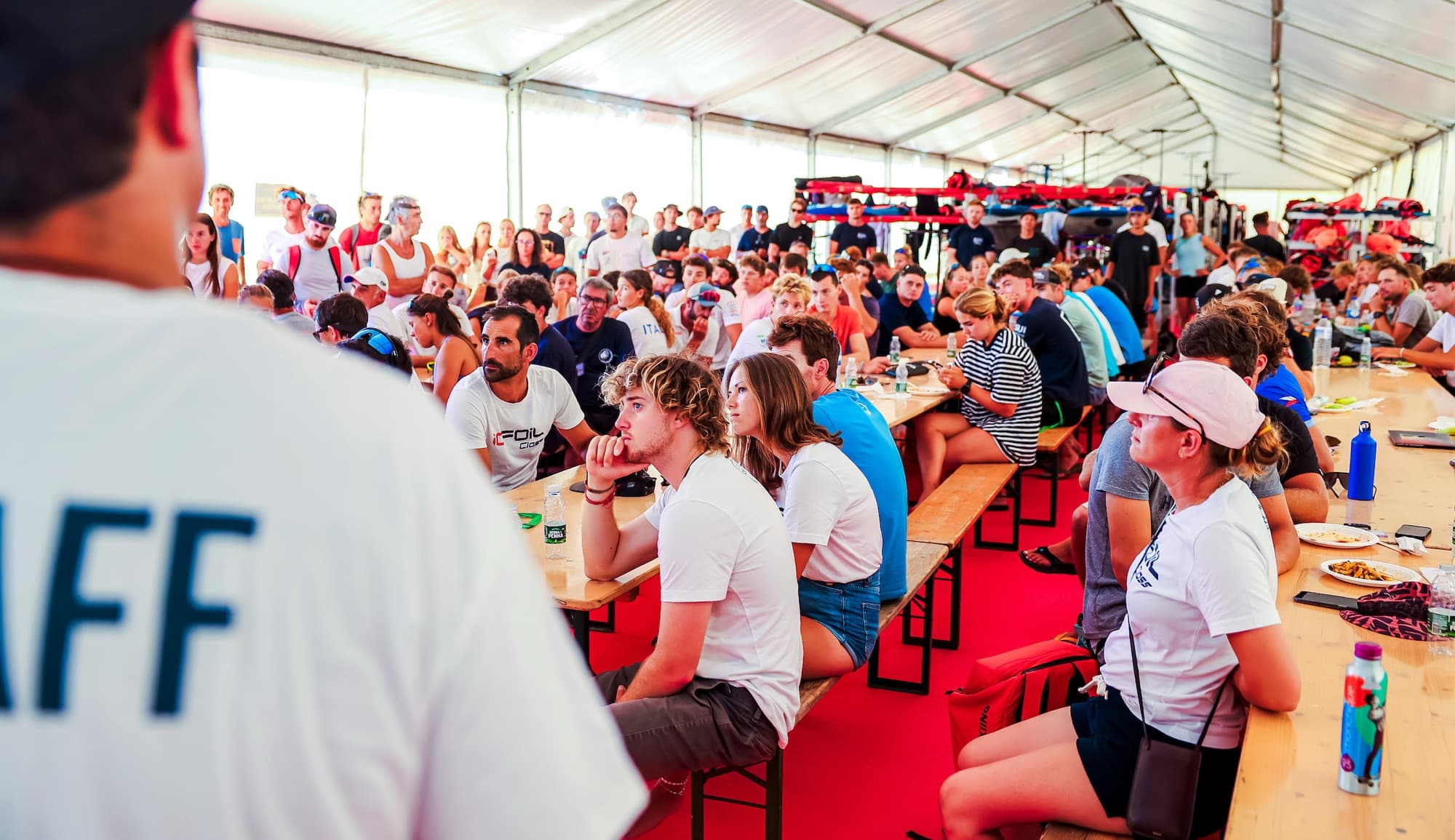 Volles Zelt beim Briefing, die Teilnehmerinnen und Teilnehmer sitzen an langen Tischen