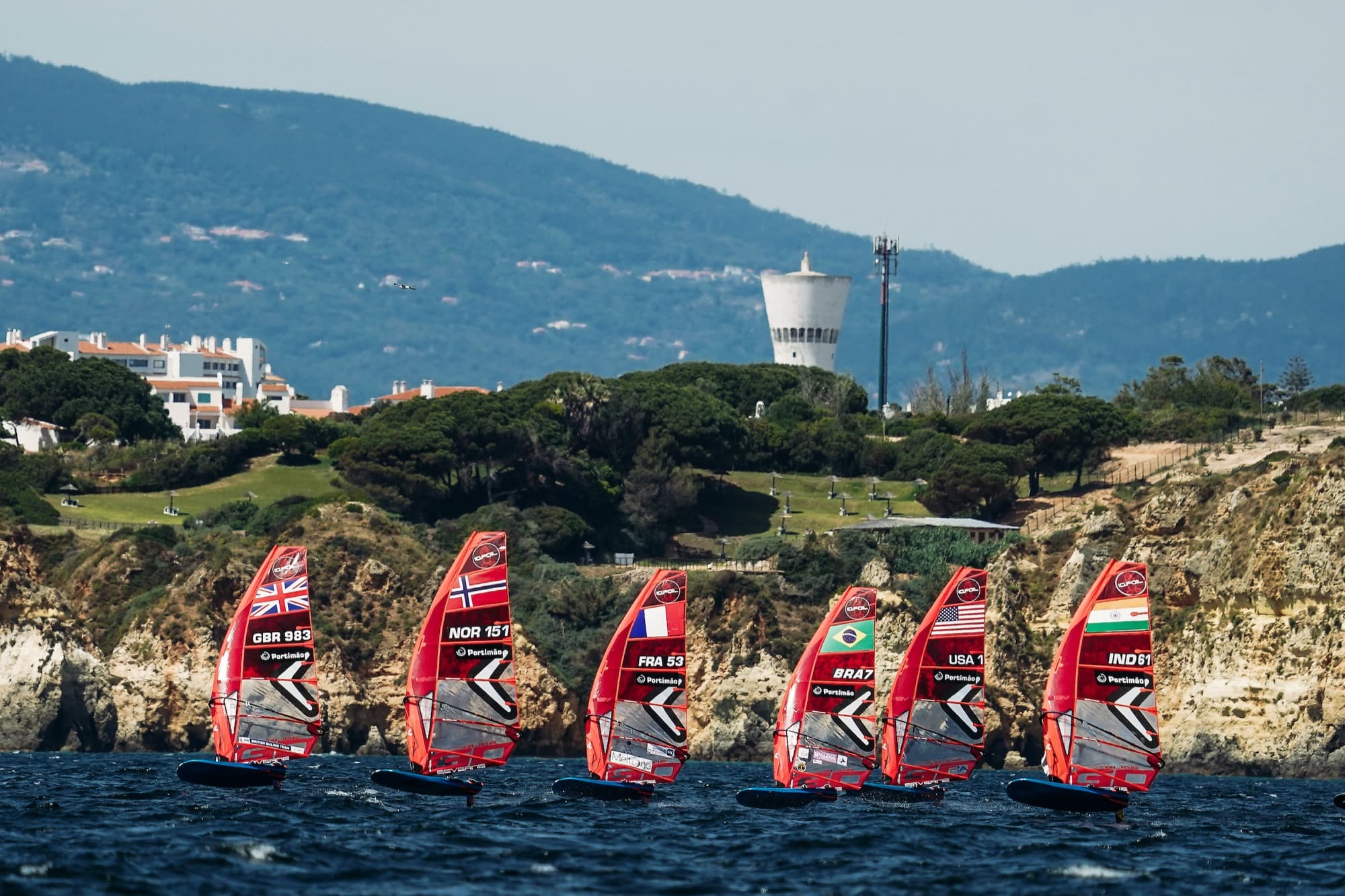 Sechs Fahrer auf einer Linie vor den Sandsteinklippen: GBR 983, NOR 151, FRA 53, BRA 7, USA 1 und IND 61