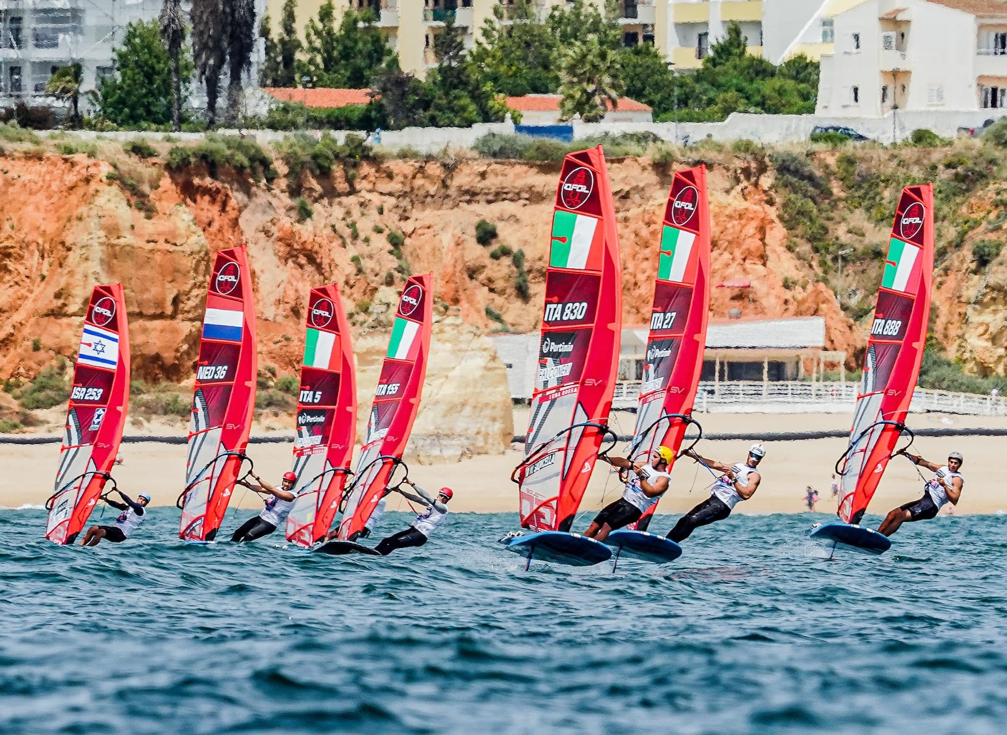 Gruppe auf dem Foil vor der roten Felswand und dem Strand, unter anderem ITA 830, ITA 27 und ITA 888
