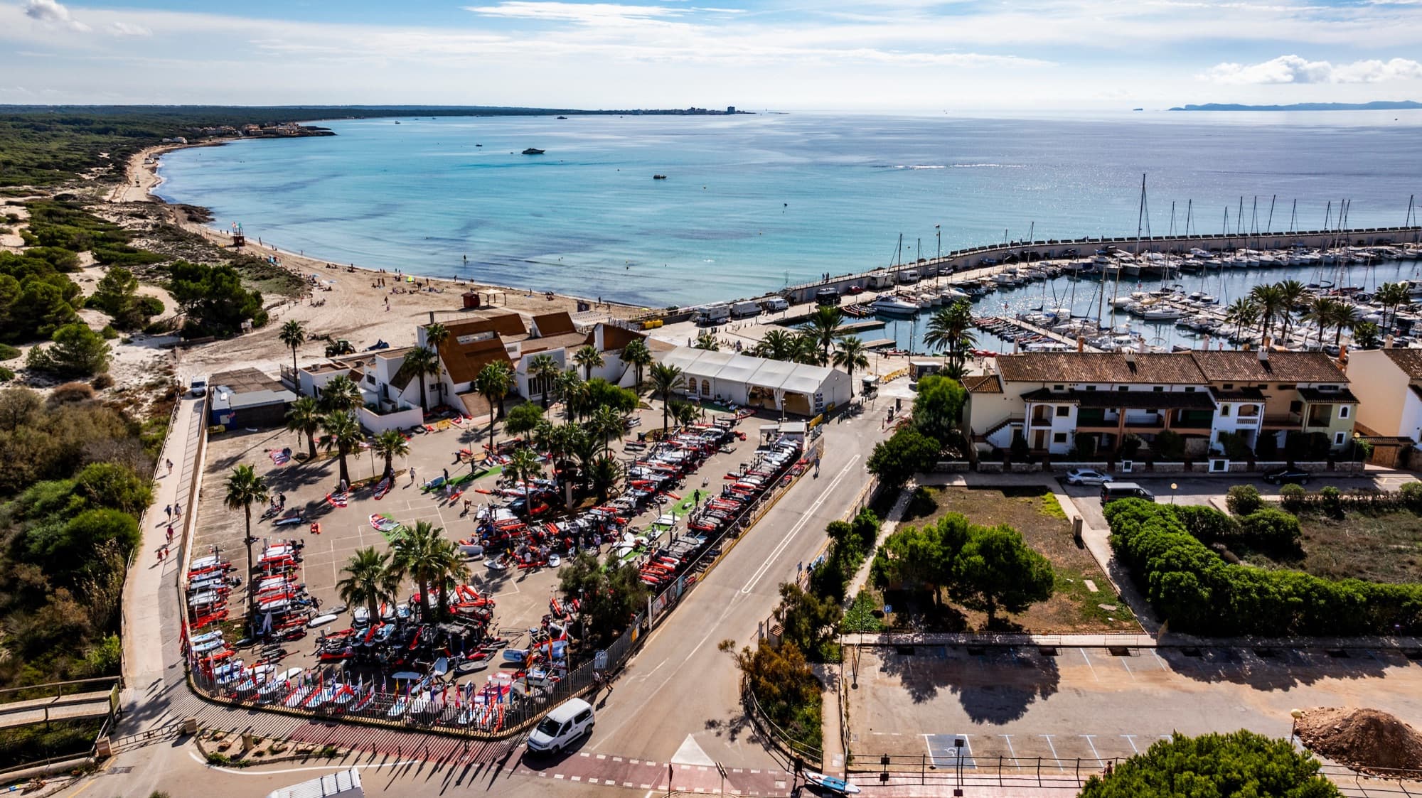 Luftaufnahme des Reviers: Boat Park am Club Nautic Sa Ràpita, dahinter der Yachthafen und die türkise Bucht