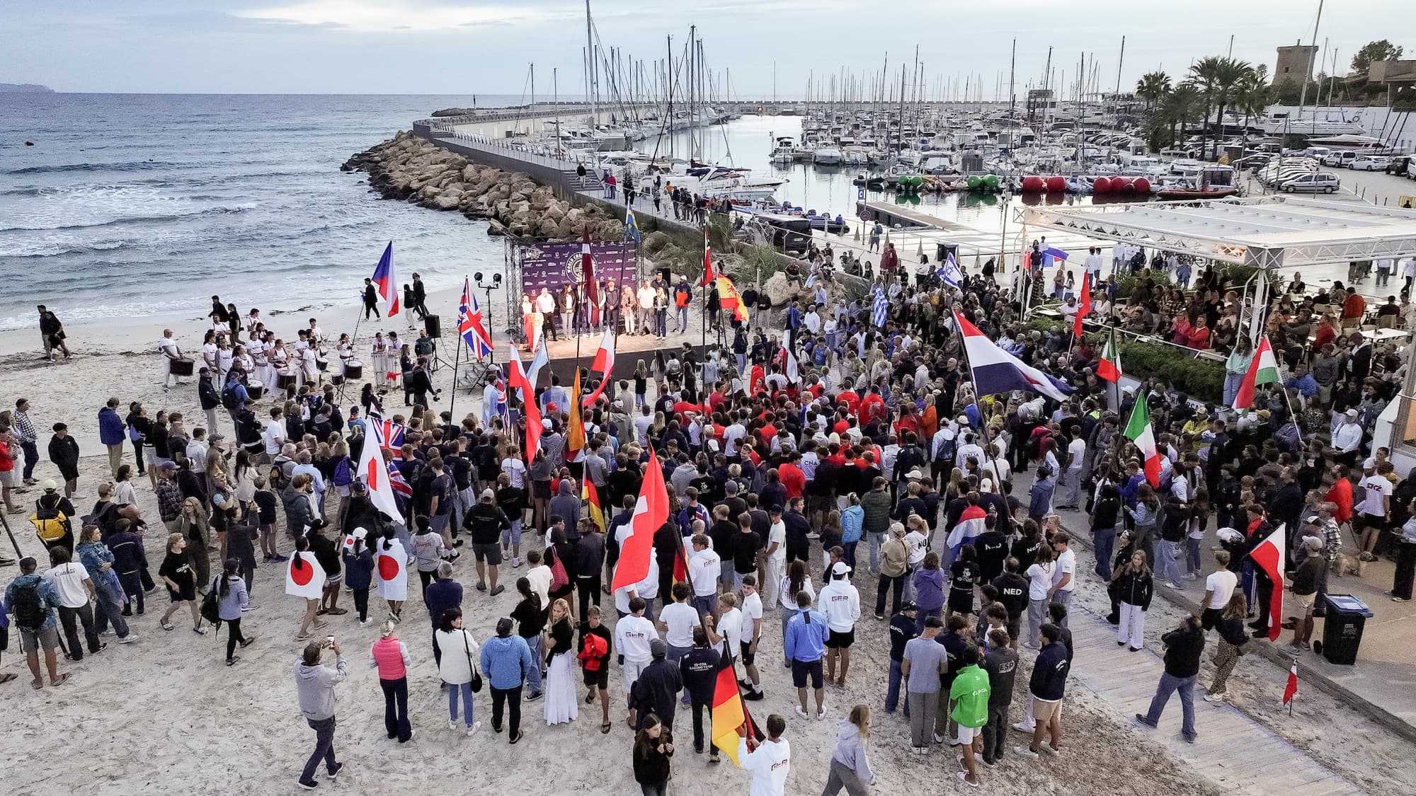 Eröffnungsfeier am Strand, die Nationen stehen mit ihren Fahnen vor der Bühne