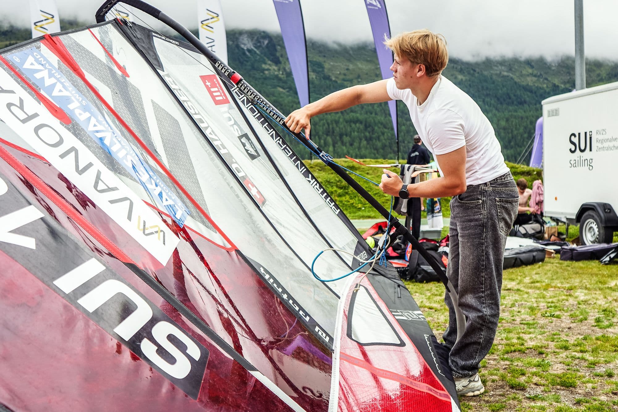 Rigg wird im Boat Park aufgebaut, dahinter der Anhänger von Swiss Sailing