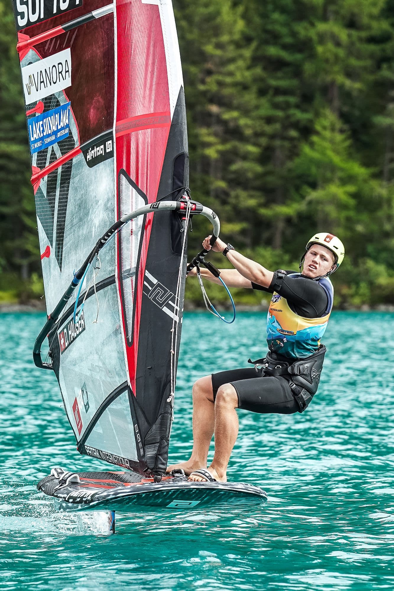 Hochformat: Devin Hauser am Trapez über türkisem Wasser