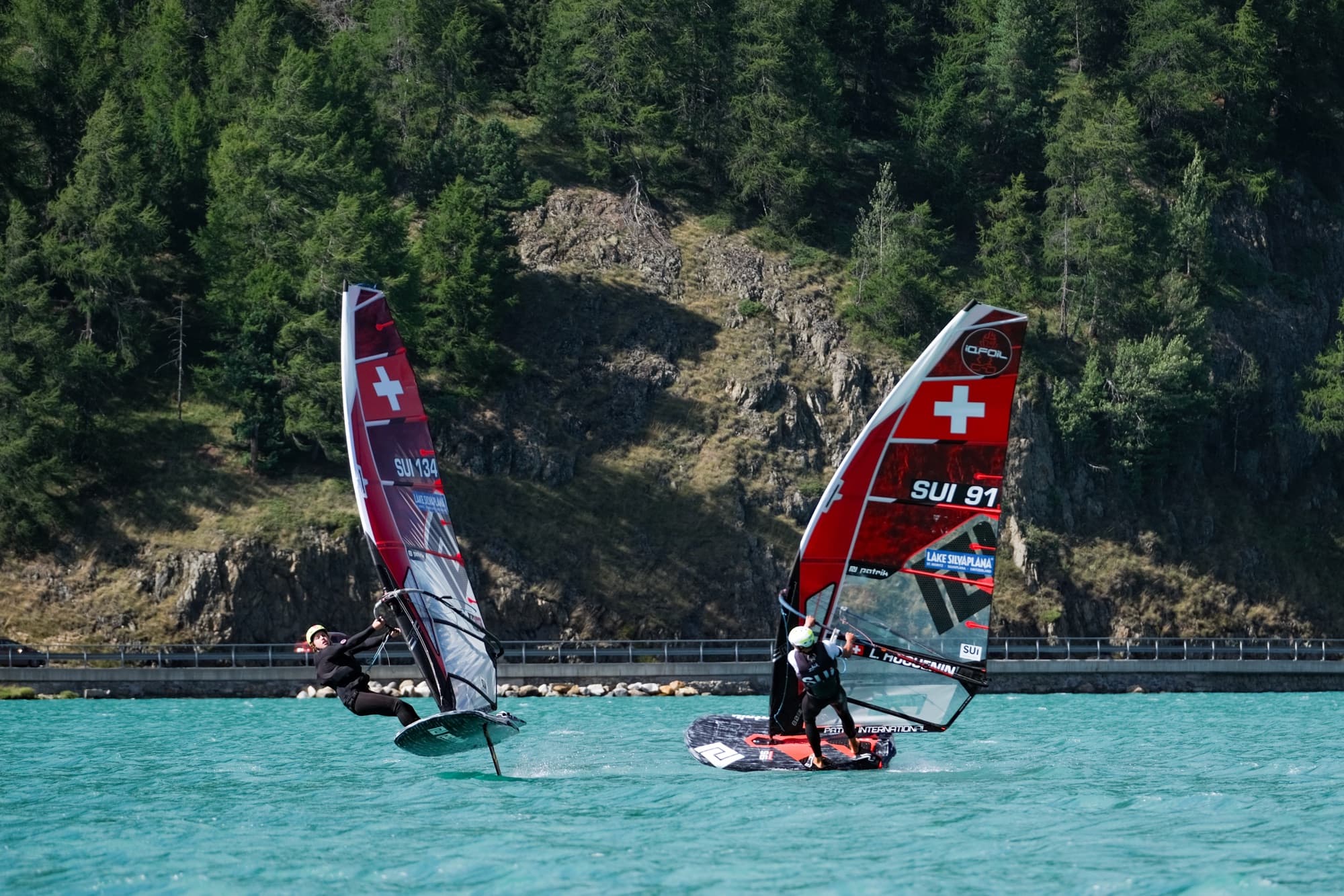 SUI 134 und SUI 91 dicht nebeneinander vor der Felswand am Ufer