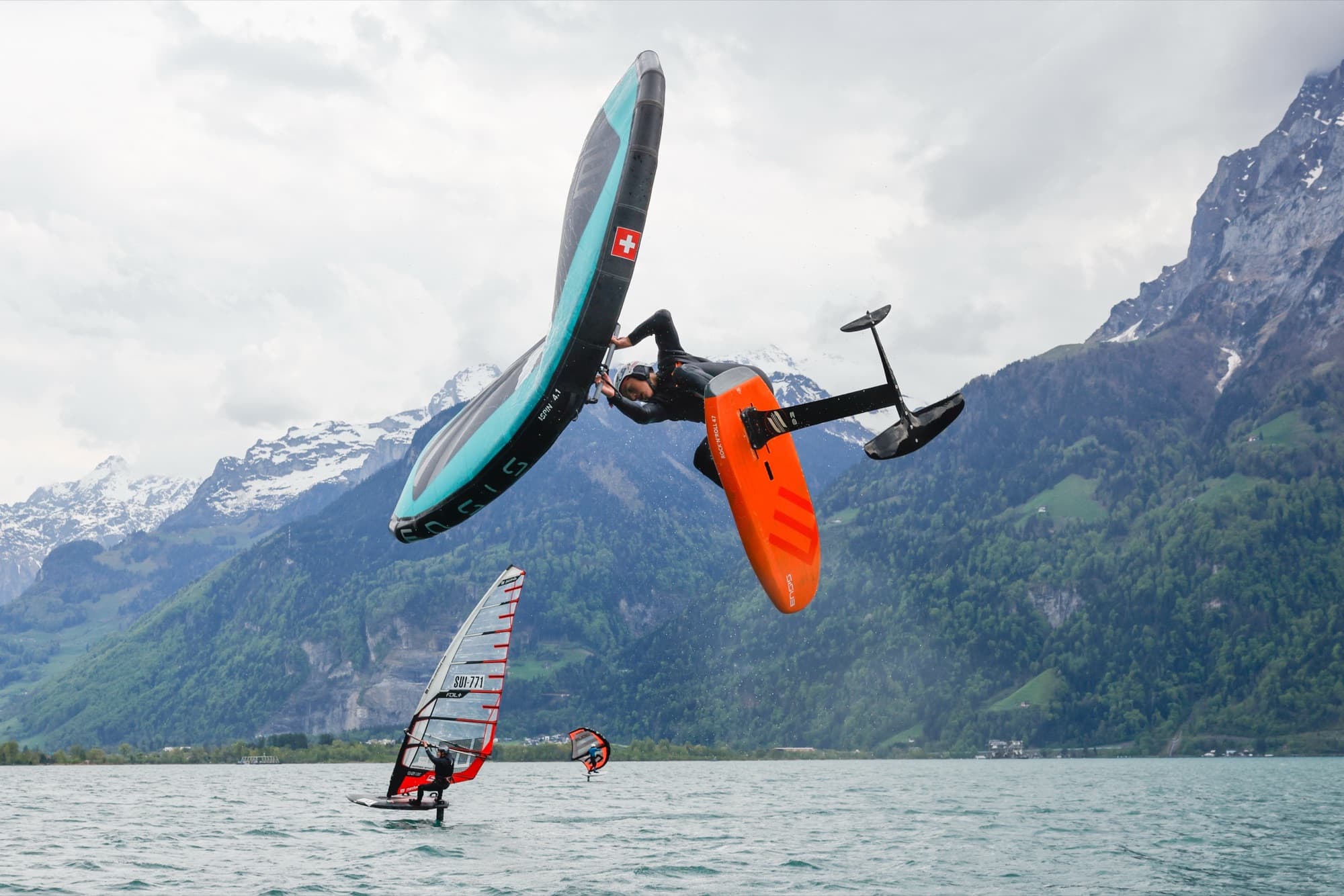 Hoher Sprung mit dem Wing, darunter ein Windsurfer und ein zweiter Wingfoiler
